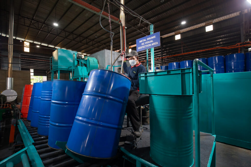 Ranama operator inspecting a metal drum on industrial equipment