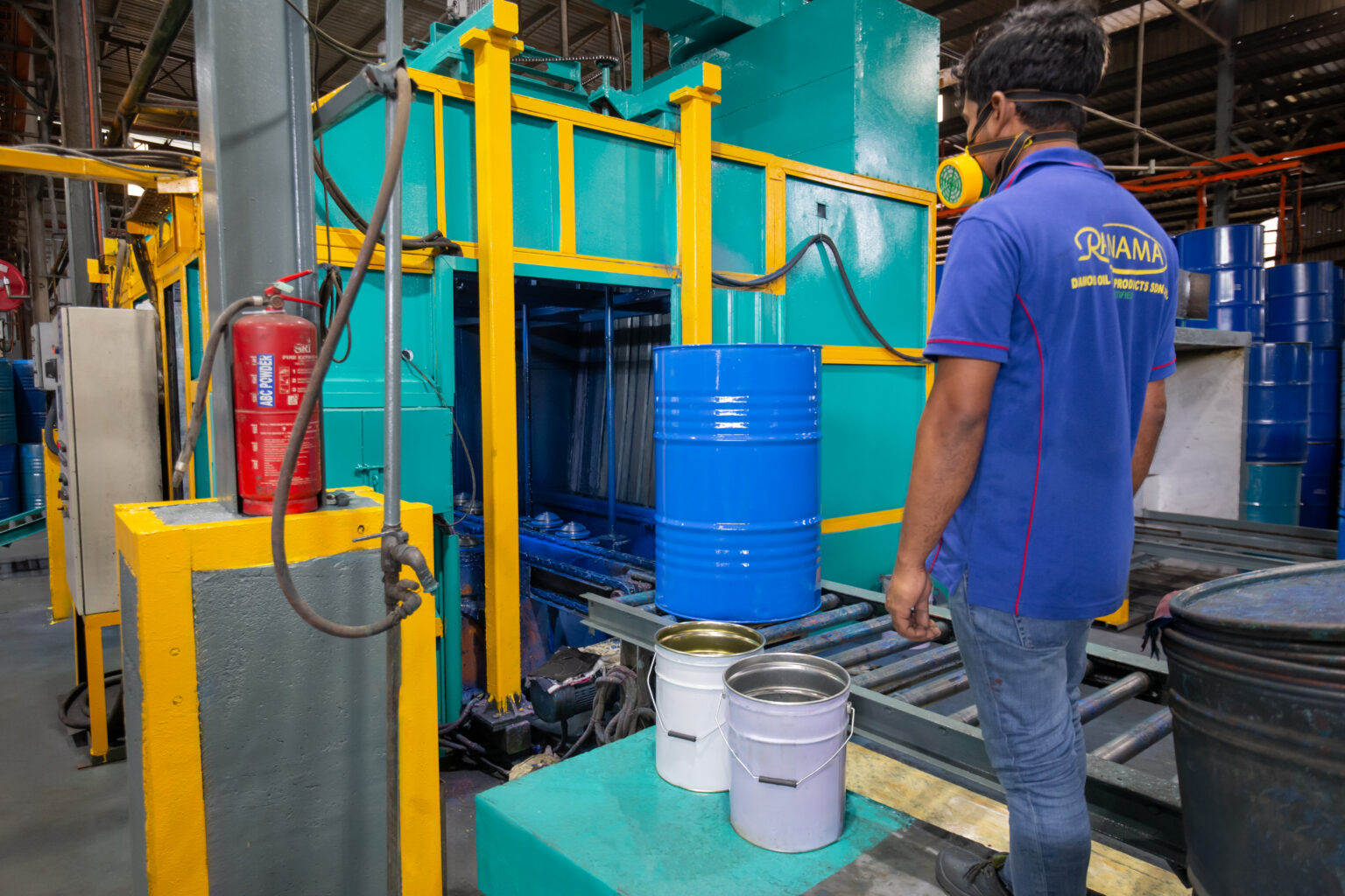 Ranama operator working at industrial drum-processing equipment