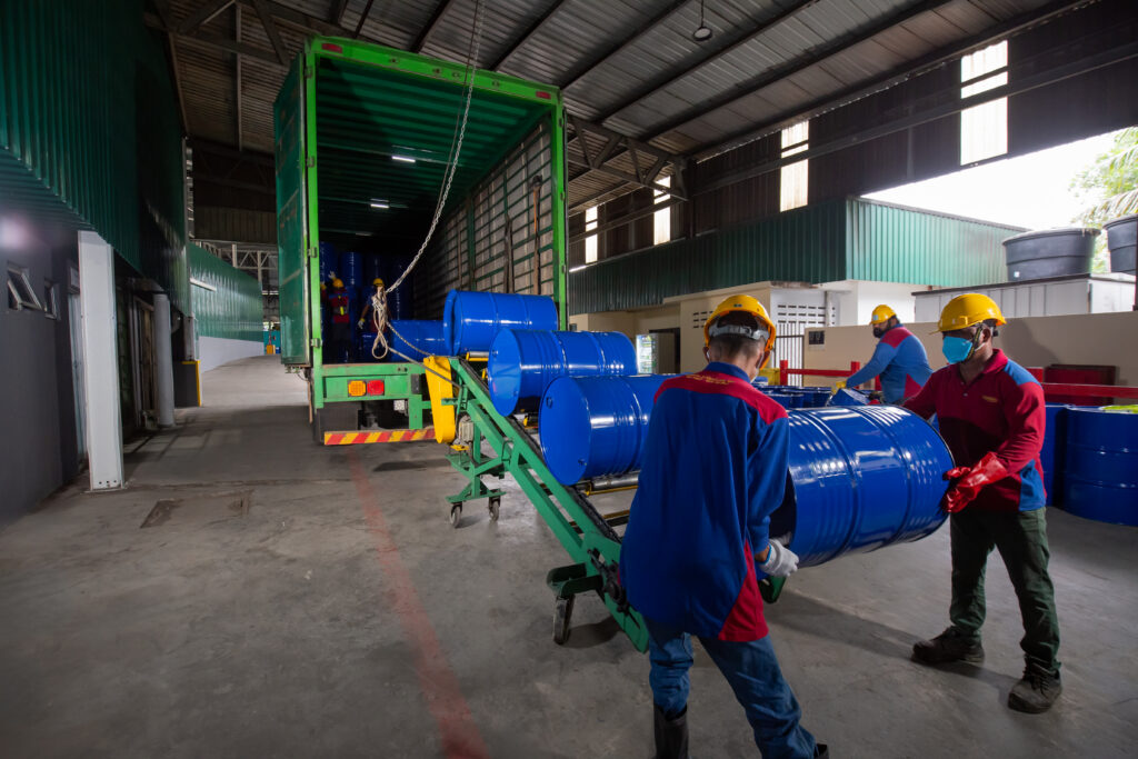 Ranama workers moving blue industrial drums into a truck