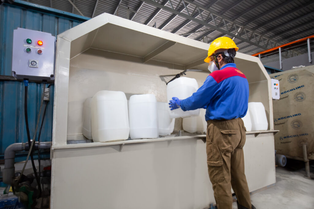 Ranama operator cleaning white jerrycans in a wash area