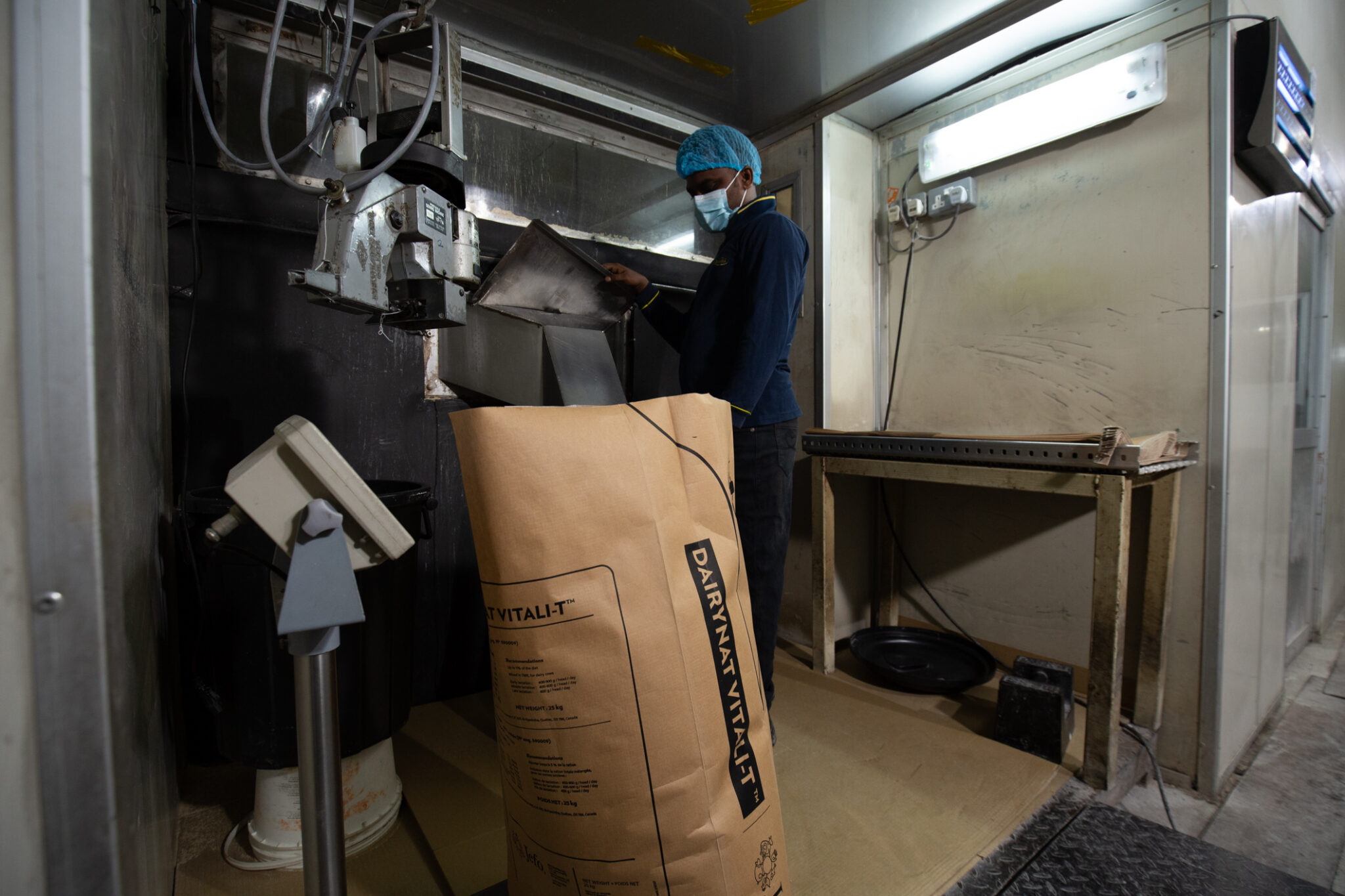 Ranama operator wearing protective equipment working beside an open industrial paper sack